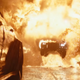 The flaming Batmobile bursts out of a giant wall of flames while in pursuit of the Penguin's car.